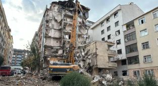 Yıkımı yapılan binadan kopan molozlar arkadaki apartmana zarar verdi