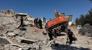 Kahramanmaraş'ta ağır hasarlı bina yıkılırken iş makinesinin üzerine devrildi
